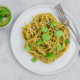 Teller mit Spaghetti aus roten Linsen mit Portulak-Pesto steht zum Essen bereit.