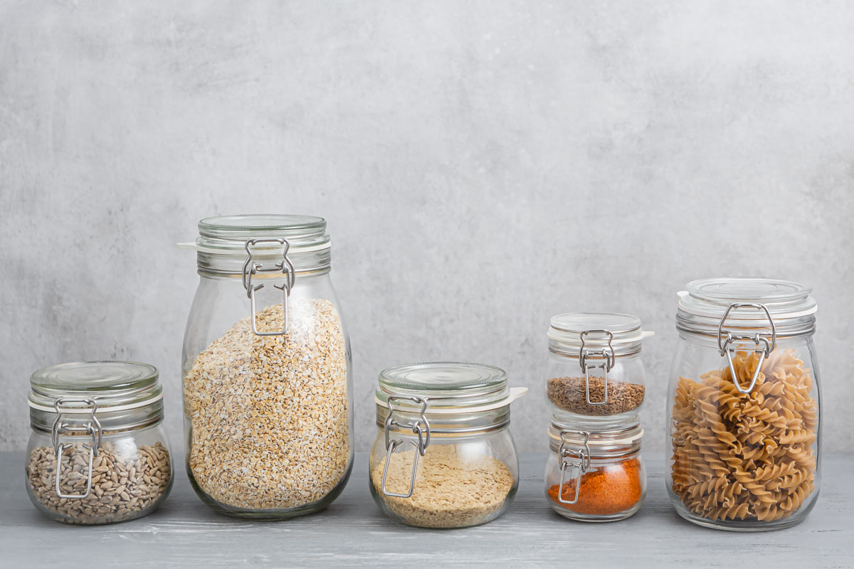 Vorräte - Gewürze, Pasta, Sonnenblumenkerne und Haferflocken in verschiedenen Vorratsgläsern